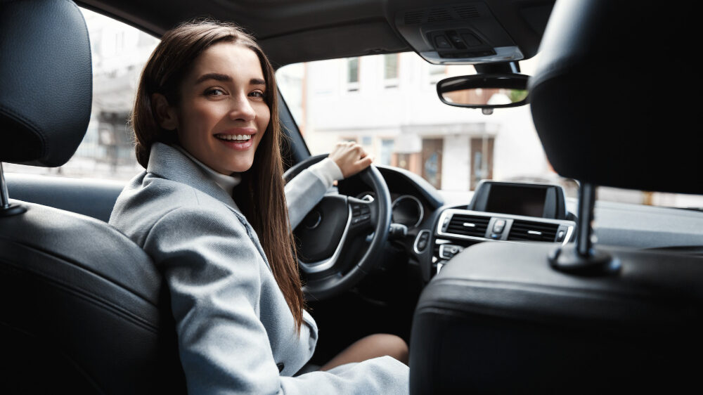 elegant woman driver looking backseat smiling happy edited