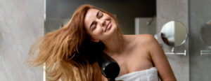 beautiful woman drying her hair bathroom e1683674149326