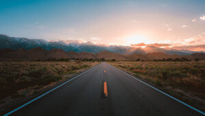 straight road middle desert with magnificent mountains sunset